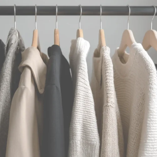 neutral clothing hanging on a rack representing a minimalist wardrobe