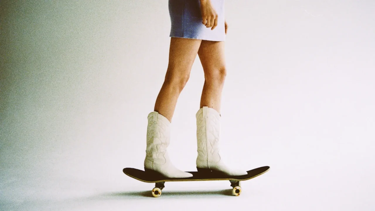 woman wearing cowboy boots on a skateboard