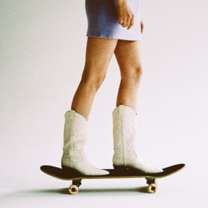 image of woman skateboarding with cowboy boots