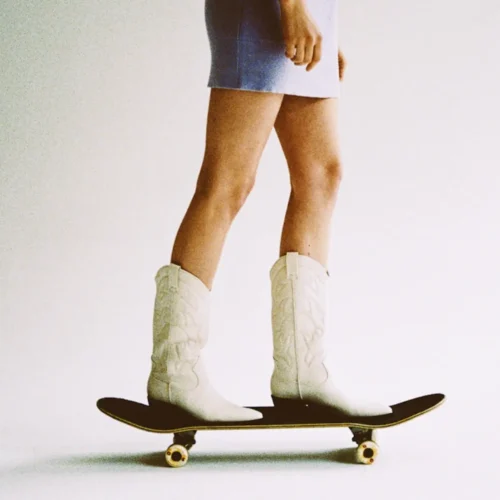 woman wearing cowboy boots on a skateboard