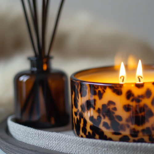 fall candle sitting on coffee table on tray with diffuser. fluffy blanket in the background